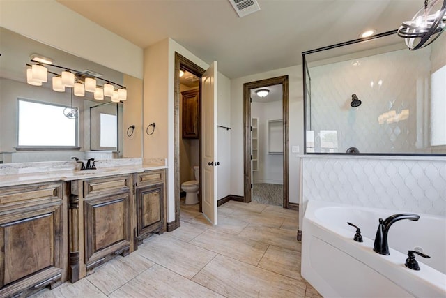 bathroom with toilet, vanity, visible vents, and a bath