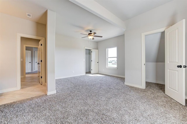 unfurnished bedroom with visible vents, a spacious closet, baseboards, and carpet flooring