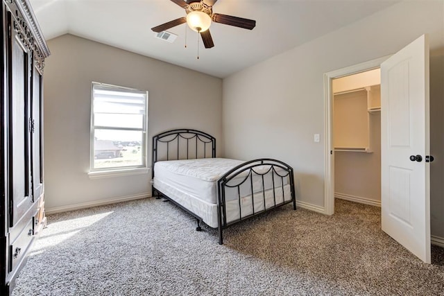 carpeted bedroom featuring visible vents, vaulted ceiling, a spacious closet, and baseboards