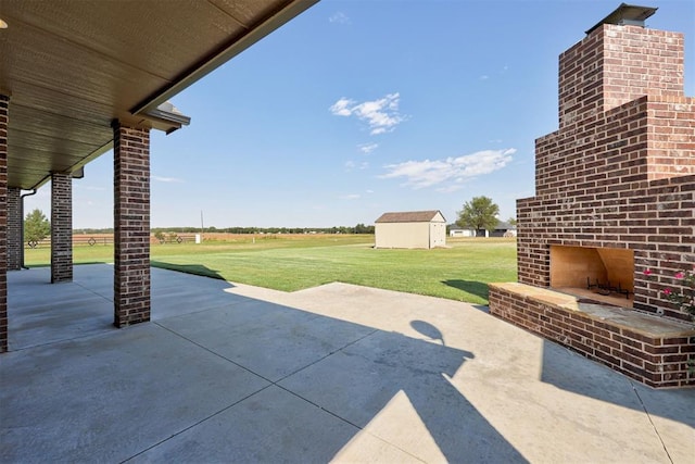 view of patio featuring an outbuilding and an outdoor brick fireplace