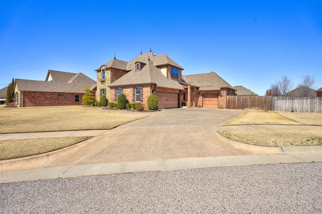 view of front of house with a garage, brick siding, concrete driveway, and fence