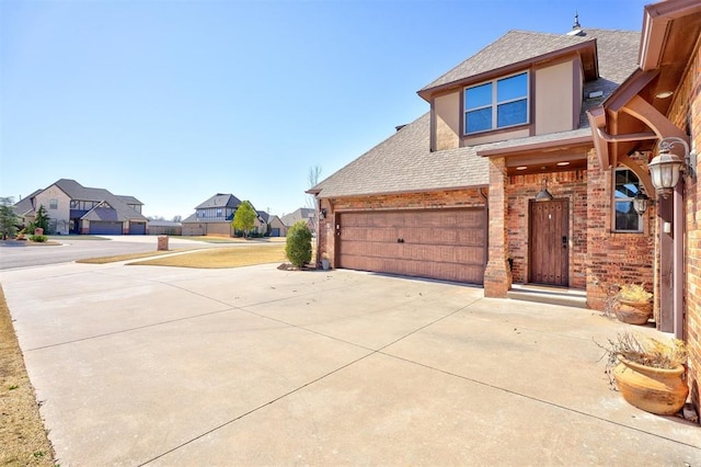 exterior space with a residential view, brick siding, driveway, and a shingled roof