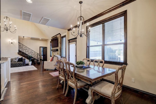 dining area featuring dark wood finished floors, a notable chandelier, stairs, and visible vents