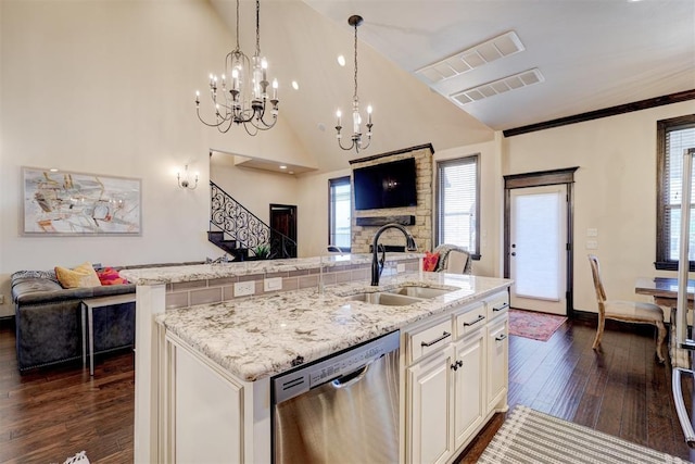 kitchen featuring stainless steel dishwasher, visible vents, open floor plan, and a sink