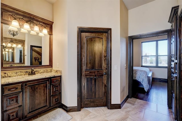 bathroom with vanity, ensuite bathroom, and baseboards