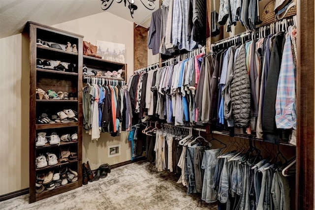 walk in closet featuring lofted ceiling and carpet