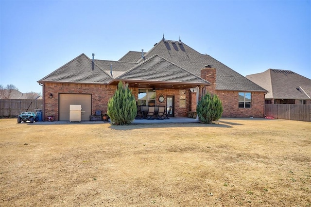 back of house featuring a patio, fence, and brick siding