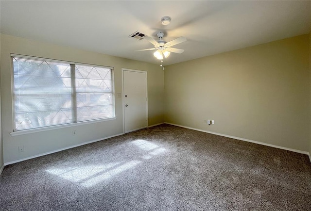 carpeted spare room with visible vents, ceiling fan, and baseboards