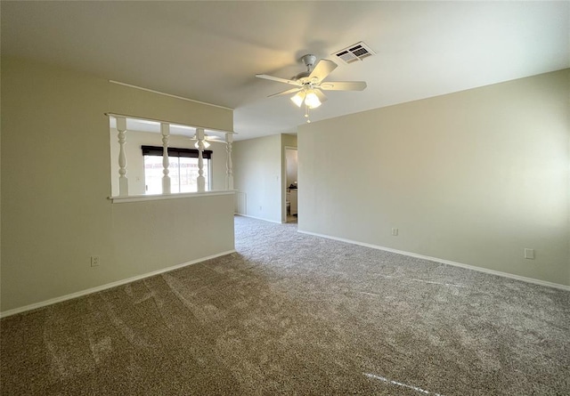 empty room featuring ceiling fan, carpet flooring, visible vents, and baseboards