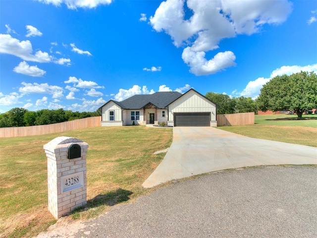 modern farmhouse featuring an attached garage, driveway, a front yard, and fence