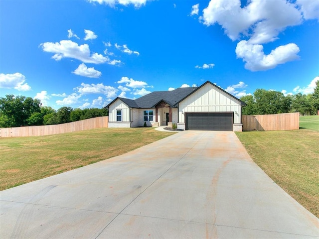 modern farmhouse style home with board and batten siding, fence, a garage, driveway, and a front lawn