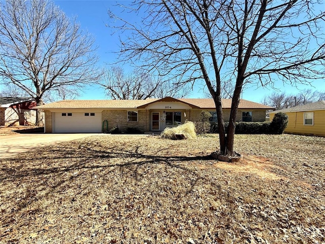 ranch-style house with a garage, driveway, and brick siding