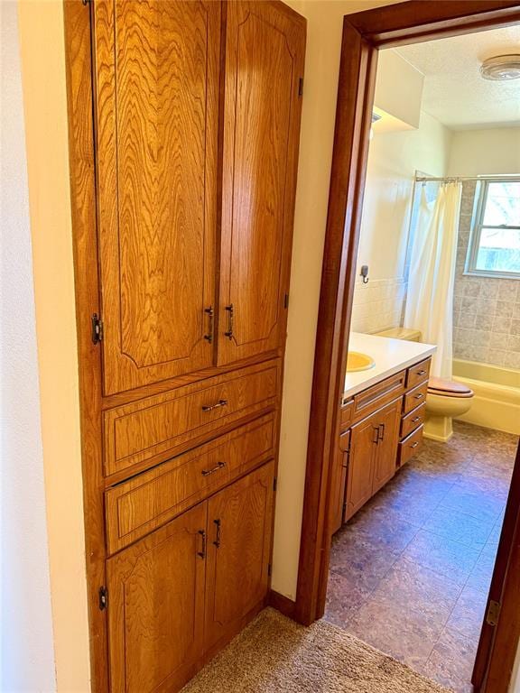 full bath featuring shower / tub combo with curtain, vanity, toilet, and a textured ceiling