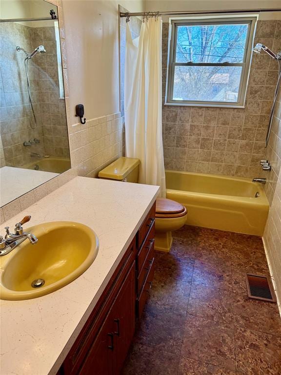 full bathroom featuring shower / bath combination with curtain, visible vents, vanity, and toilet