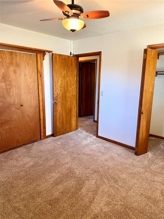 unfurnished bedroom featuring ceiling fan, carpet floors, and baseboards