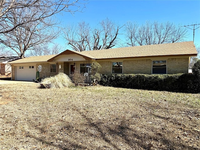 ranch-style home featuring an attached garage and brick siding