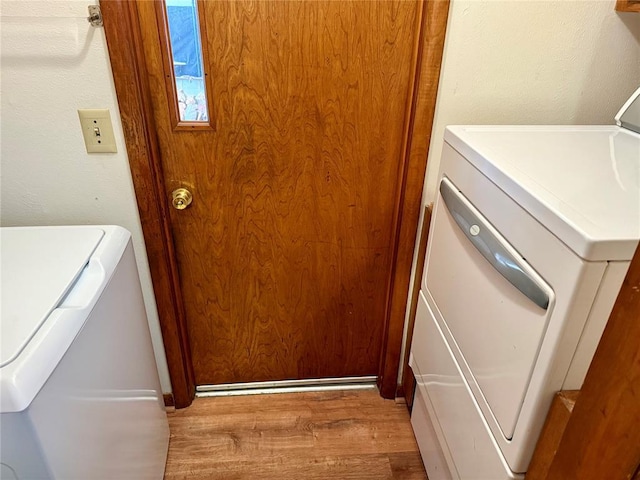 laundry room featuring washing machine and dryer, laundry area, and wood finished floors