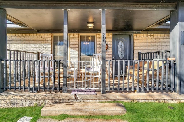 property entrance with brick siding and covered porch