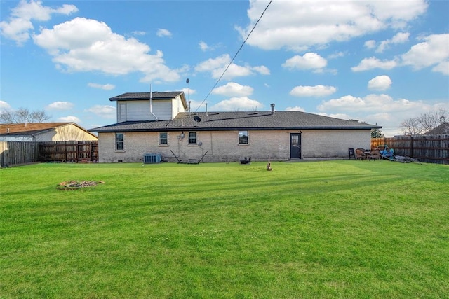 rear view of property with a lawn and a fenced backyard