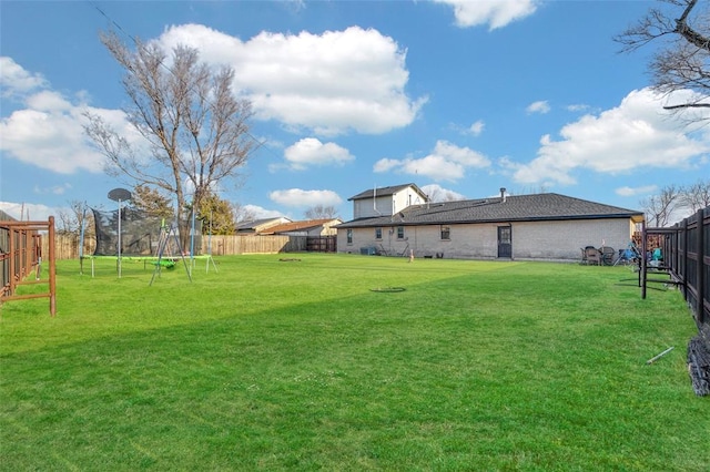 view of yard with a fenced backyard and a trampoline