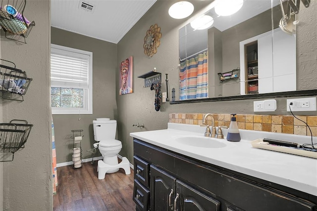 full bathroom featuring visible vents, toilet, wood finished floors, a textured wall, and vanity