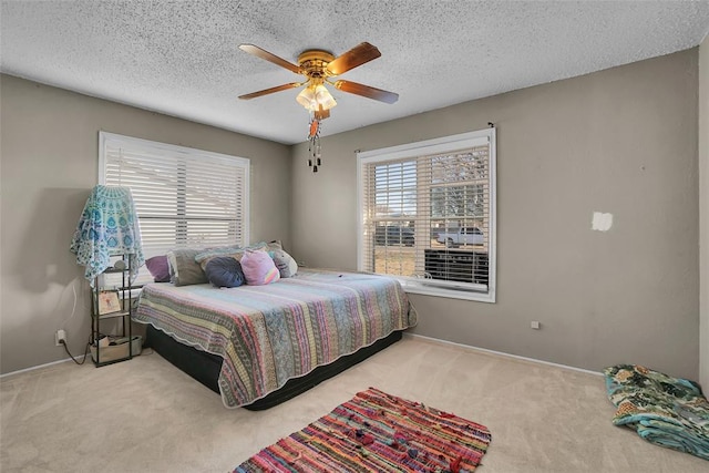 carpeted bedroom with baseboards, a textured ceiling, and a ceiling fan