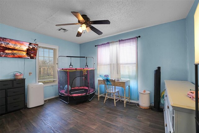 interior space featuring wood finished floors, baseboards, visible vents, ceiling fan, and a textured ceiling