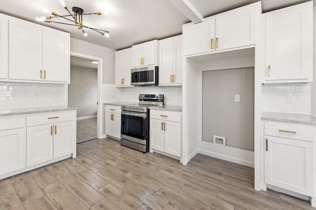 kitchen featuring appliances with stainless steel finishes, light wood-type flooring, backsplash, and white cabinetry