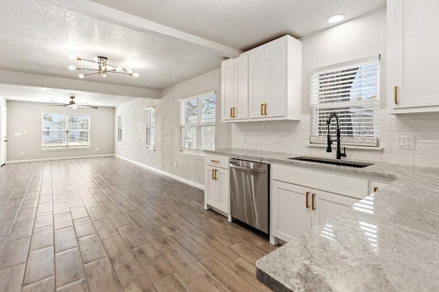 kitchen featuring stainless steel dishwasher, backsplash, light wood-type flooring, and a sink