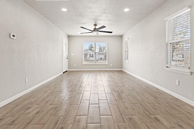 unfurnished living room featuring baseboards, a ceiling fan, and wood finished floors