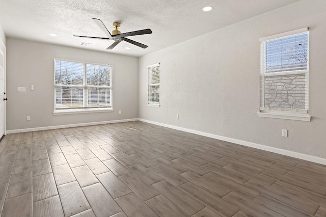 empty room with baseboards, a ceiling fan, dark wood-style flooring, a textured ceiling, and recessed lighting