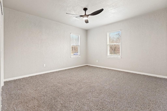 empty room with carpet, a ceiling fan, and a textured wall