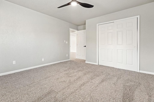 unfurnished bedroom featuring carpet floors, ceiling fan, baseboards, and a closet