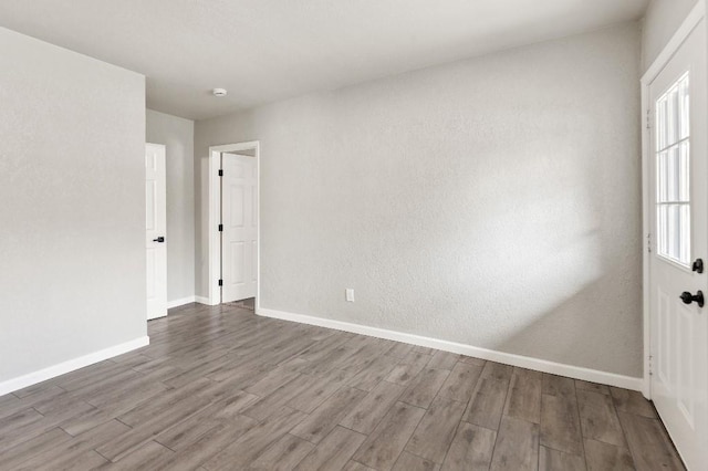 spare room featuring wood finished floors and baseboards