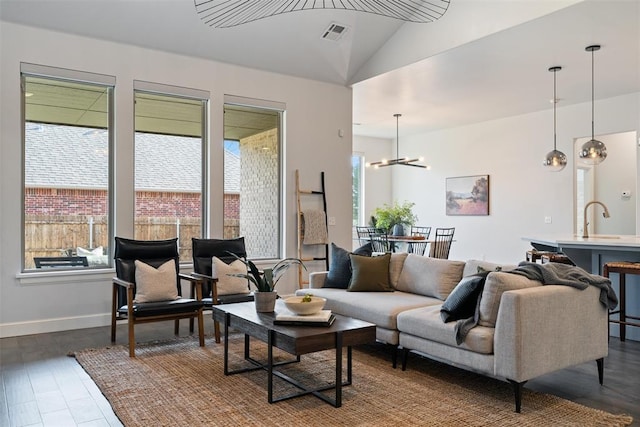 living room featuring visible vents, a chandelier, baseboards, dark wood-style floors, and vaulted ceiling