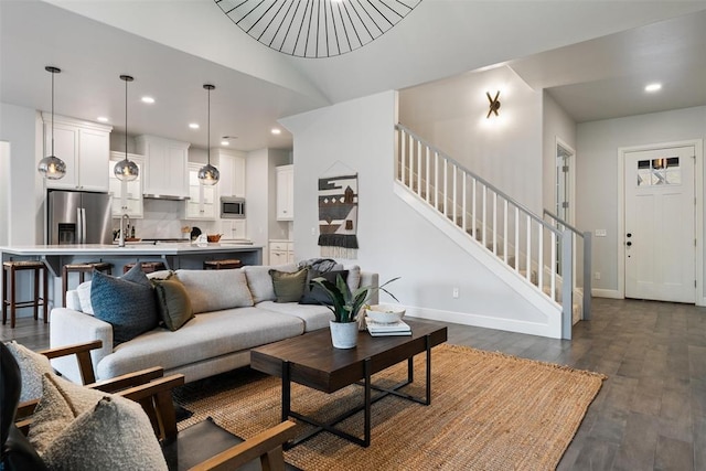 living area with baseboards, recessed lighting, stairway, and dark wood finished floors