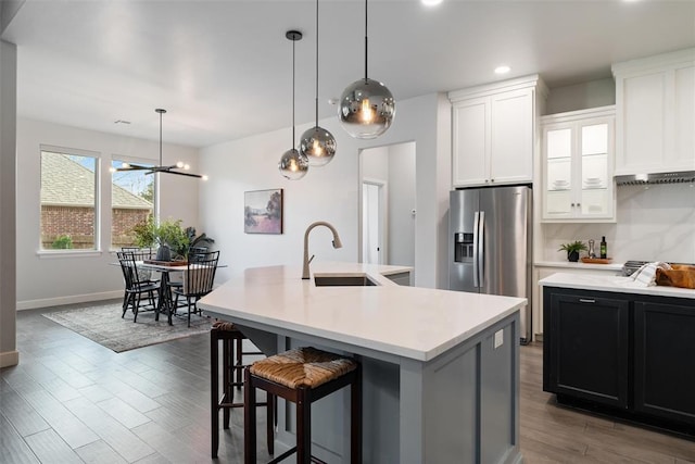 kitchen featuring dark wood-style floors, light countertops, a sink, and stainless steel refrigerator with ice dispenser