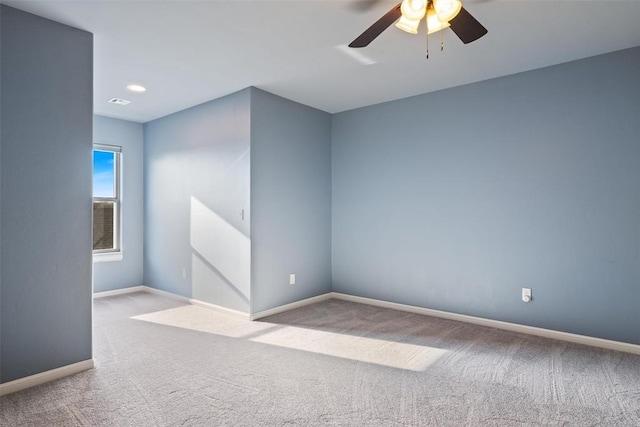 spare room with baseboards, a ceiling fan, and carpet