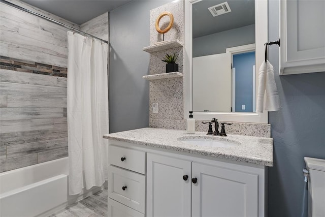 bathroom with visible vents, toilet, shower / tub combo with curtain, and vanity