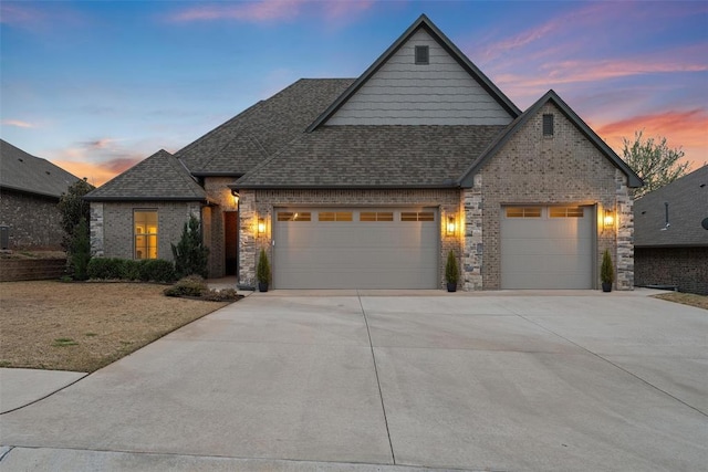 view of front facade featuring driveway, an attached garage, brick siding, and roof with shingles