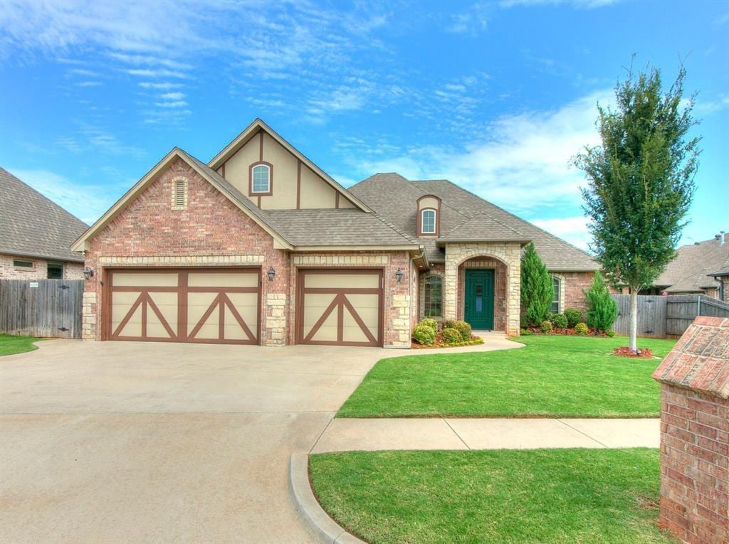 view of front of property with roof with shingles, concrete driveway, fence, a garage, and a front lawn