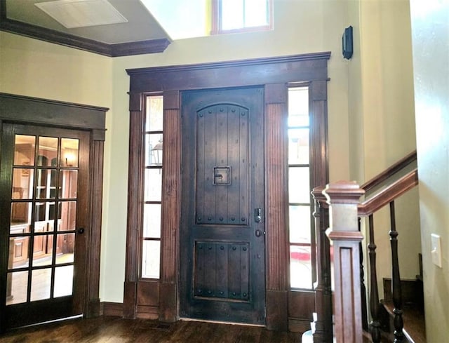 entryway with crown molding, stairway, and wood finished floors