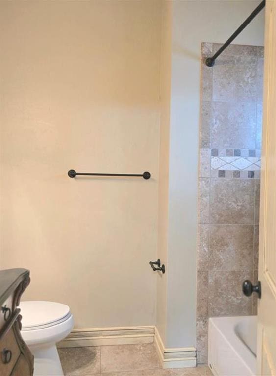 bathroom with washtub / shower combination, toilet, and baseboards