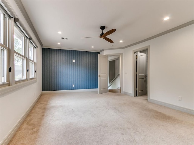 empty room with recessed lighting, light colored carpet, crown molding, and baseboards