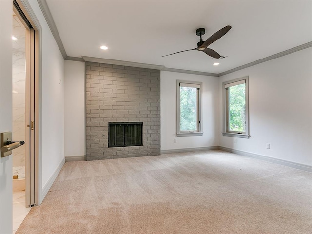 unfurnished living room with baseboards, carpet floors, a brick fireplace, and crown molding