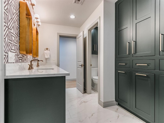 bathroom featuring marble finish floor, recessed lighting, toilet, vanity, and baseboards