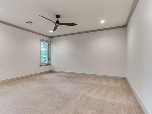 spare room featuring visible vents, light carpet, ornamental molding, baseboards, and ceiling fan