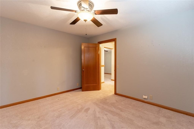 unfurnished room with light carpet, ceiling fan, and baseboards