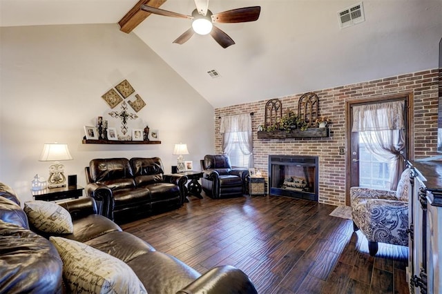 living room with visible vents, a fireplace, beamed ceiling, and wood finished floors