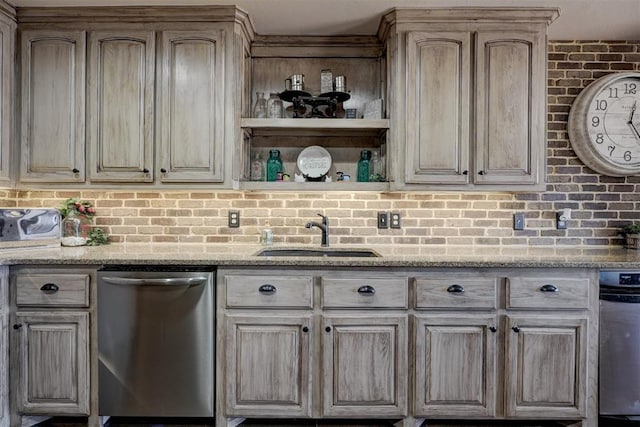 kitchen with light stone counters, brick wall, a sink, stainless steel dishwasher, and open shelves